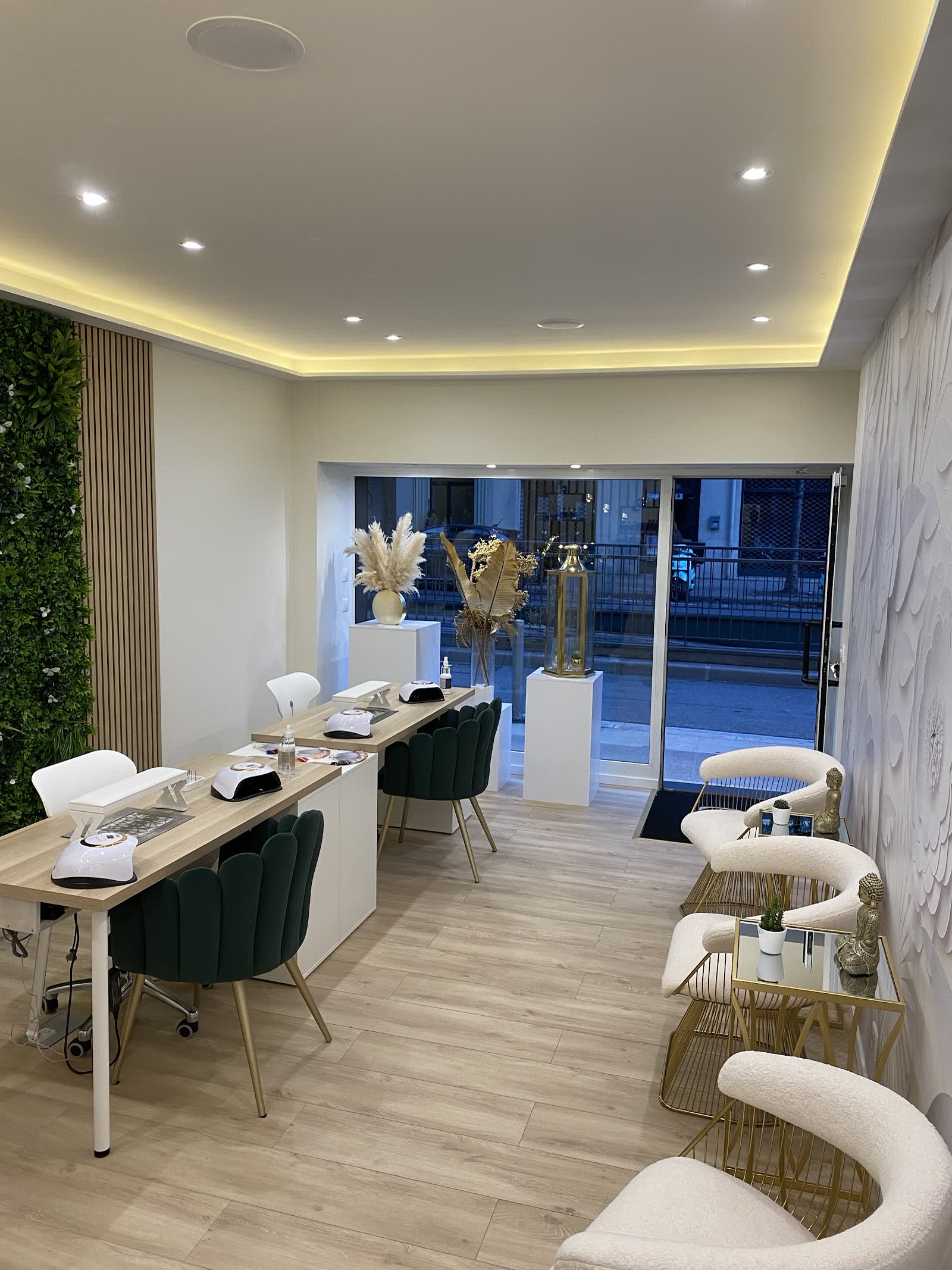 Espace manucure aux fauteuils vert profond et tables de soin des ongles